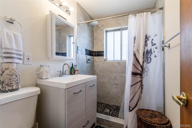9486 Pelon Dr, Denver, CO 80260 - bathroom with tiled shower, vanity, and toilet