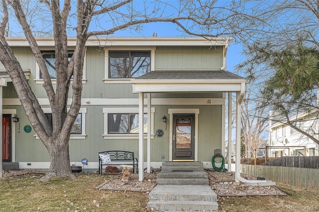 view of front of property with roof with shingles and fence