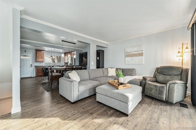 living area featuring dark wood-style floors, visible vents, and crown molding