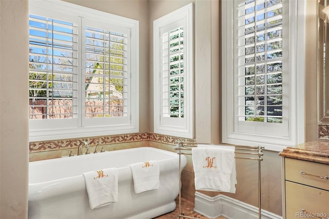 full bathroom featuring a freestanding tub and a wealth of natural light