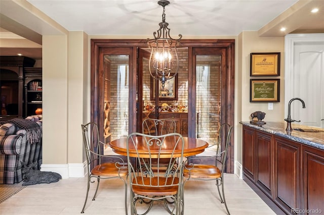 dining space with baseboards and a chandelier