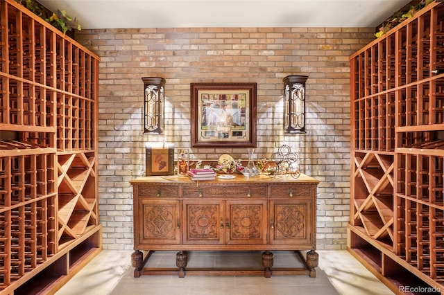 wine room featuring brick wall and light tile patterned floors