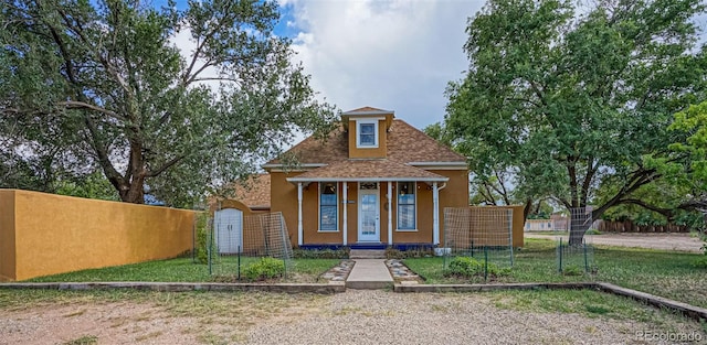 bungalow-style home with roof with shingles, fence, and stucco siding