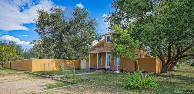 view of front of house with stucco siding, fence, and a front yard