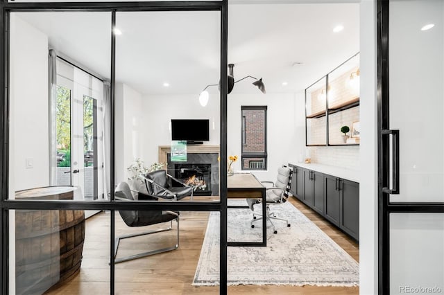 office with light wood-type flooring, a fireplace, and recessed lighting