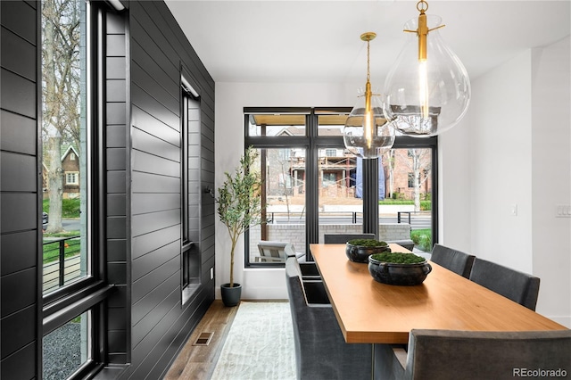 dining area featuring an inviting chandelier, visible vents, and wood finished floors