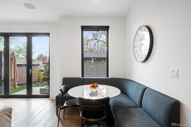 dining space with french doors, plenty of natural light, and hardwood / wood-style flooring