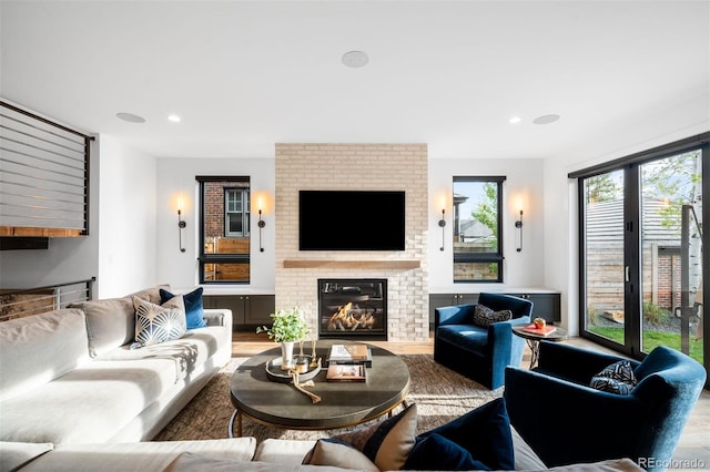 living area featuring a fireplace, recessed lighting, and wood finished floors