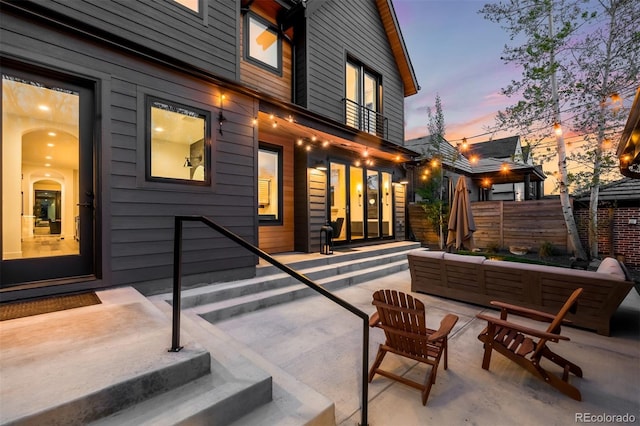 patio terrace at dusk featuring fence