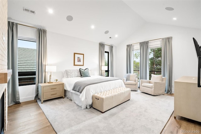 bedroom featuring lofted ceiling, visible vents, recessed lighting, a fireplace, and light wood finished floors