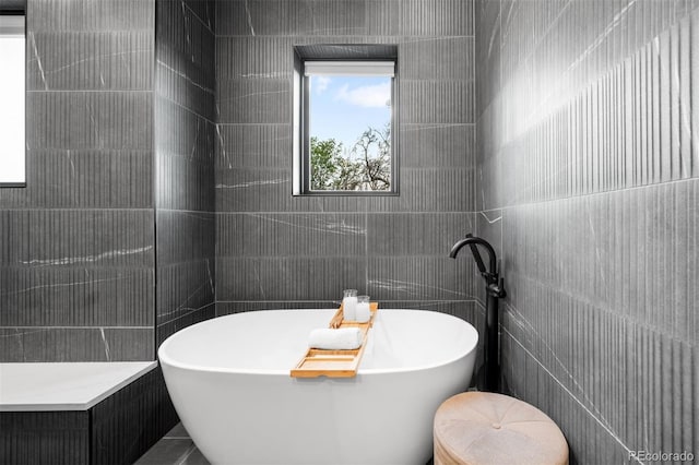 bathroom featuring a freestanding bath and tile walls