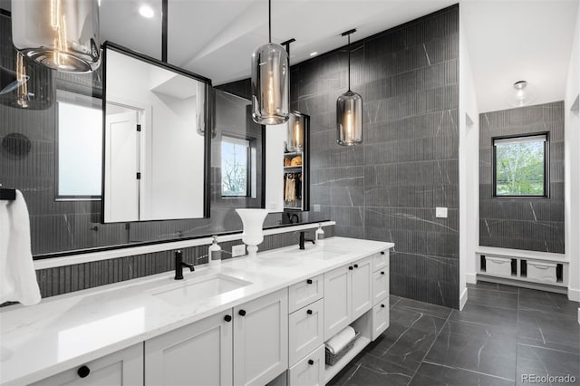 bathroom featuring double vanity, tile walls, marble finish floor, and a sink