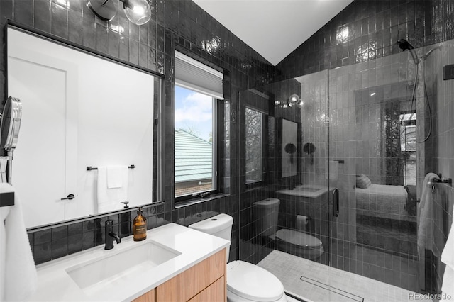bathroom featuring lofted ceiling, a stall shower, toilet, vanity, and tasteful backsplash