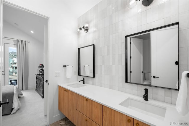bathroom with a sink, double vanity, and tile walls