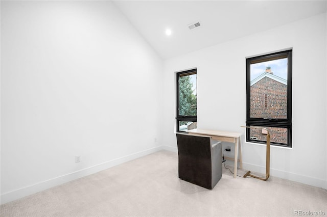 unfurnished office with light colored carpet, visible vents, baseboards, and high vaulted ceiling