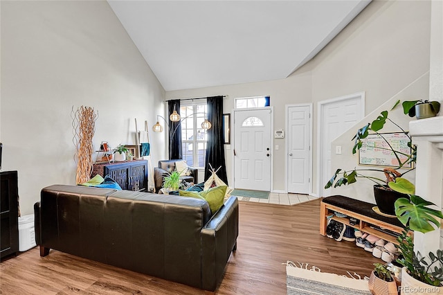 living room with light wood-style flooring and high vaulted ceiling