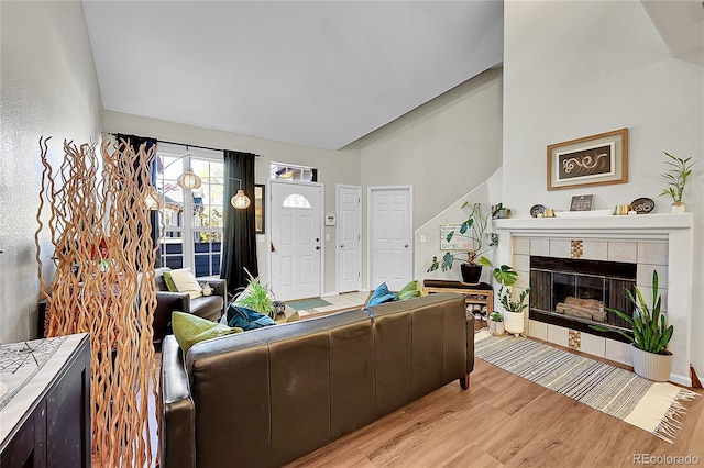 living room featuring light wood-style flooring and a tile fireplace