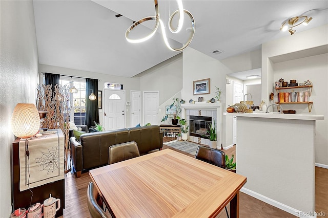 dining area with a chandelier, a tile fireplace, and baseboards