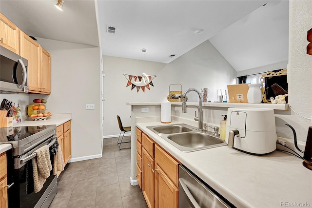 kitchen with appliances with stainless steel finishes, a sink, light countertops, light tile patterned floors, and light brown cabinets