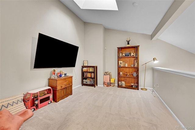 carpeted living area with a skylight and baseboards