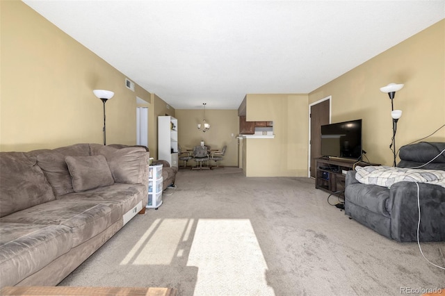 living room featuring light carpet and a notable chandelier