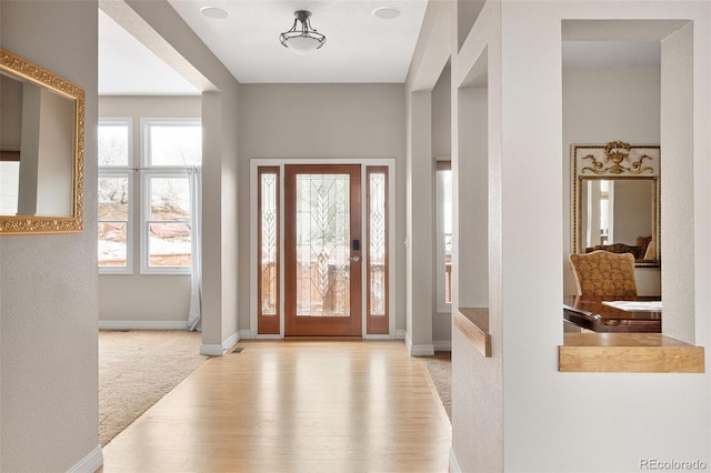 foyer entrance featuring baseboards and wood finished floors