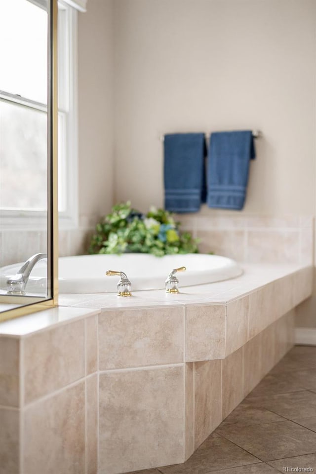 full bathroom with a wealth of natural light, tile patterned flooring, and a garden tub