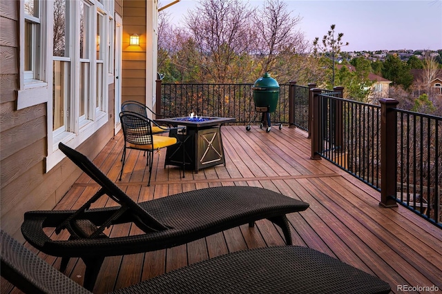 wooden deck with area for grilling and an outdoor fire pit