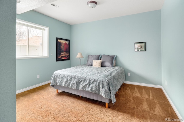 carpeted bedroom with visible vents and baseboards