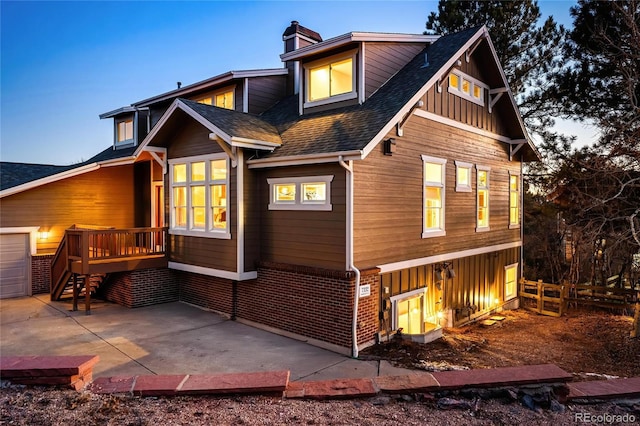 back of house featuring fence, a shingled roof, brick siding, a chimney, and a patio area