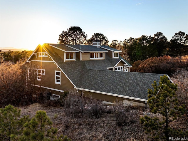 rear view of property featuring roof with shingles