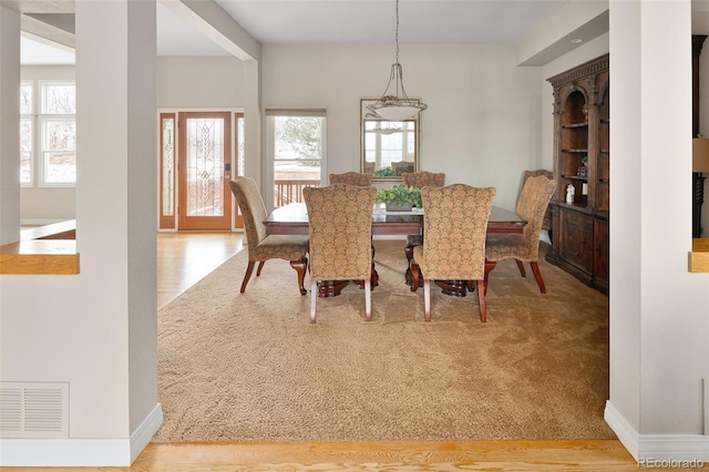 dining room featuring visible vents, baseboards, and wood finished floors