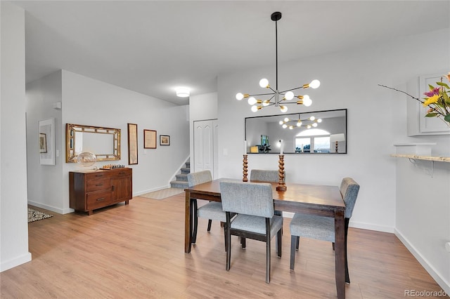 dining space featuring stairway, baseboards, light wood-style floors, and a chandelier