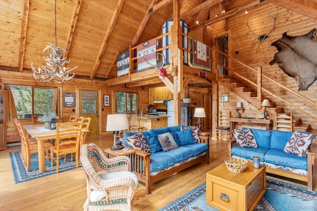 living room featuring a notable chandelier, wood walls, and light wood-type flooring