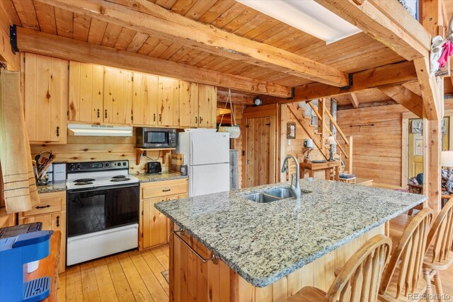 kitchen with beamed ceiling, white appliances, sink, and wooden walls