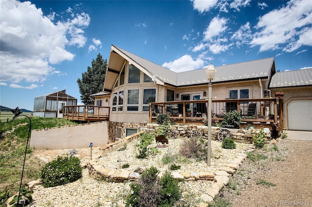 rear view of house with a garage and a deck