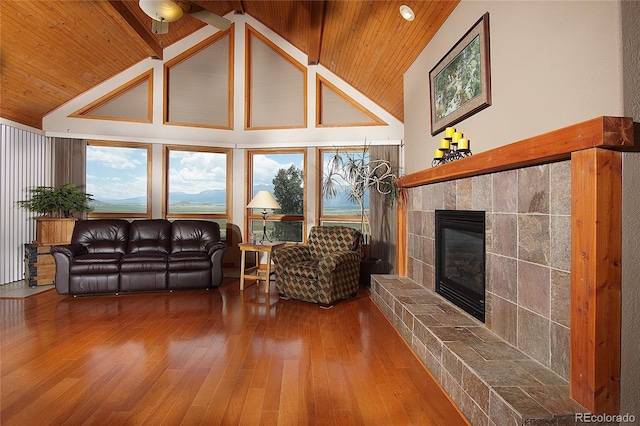 living room with wood ceiling, a tile fireplace, and hardwood / wood-style floors