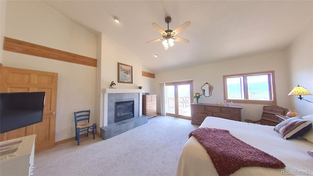 bedroom featuring a tiled fireplace, ceiling fan, light colored carpet, and access to exterior