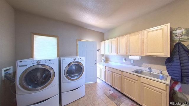 washroom featuring light tile patterned floors, sink, a textured ceiling, cabinets, and washer and dryer