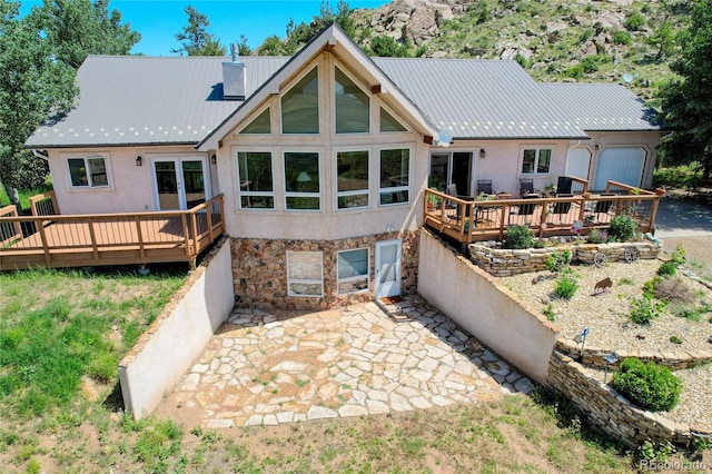 back of house with a garage and a wooden deck