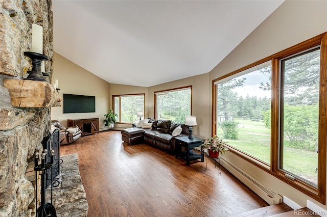 8788 E Tanglewood Rd, Franktown, CO 80116 - living area with lofted ceiling, a fireplace, wood finished floors, and a baseboard heating unit
