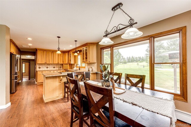8788 E Tanglewood Rd, Franktown, CO 80116 - dining area featuring a baseboard heating unit, light wood-style floors, recessed lighting, and baseboards