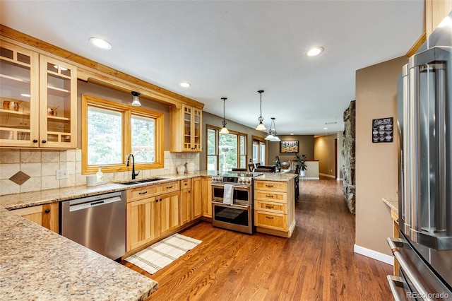 8788 E Tanglewood Rd, Franktown, CO 80116 - kitchen featuring high quality appliances, a sink, a peninsula, dark wood-type flooring, and backsplash