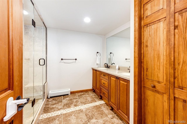 8788 E Tanglewood Rd, Franktown, CO 80116 - bathroom featuring a baseboard heating unit, double vanity, a stall shower, and baseboards