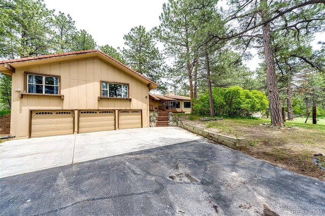 8788 E Tanglewood Rd, Franktown, CO 80116 - view of front of house with driveway, a garage, and board and batten siding
