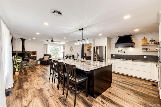 8788 E Tanglewood Rd, Franktown, CO 80116 - kitchen featuring stainless steel fridge with ice dispenser, custom exhaust hood, dark wood-style flooring, white cabinets, and recessed lighting