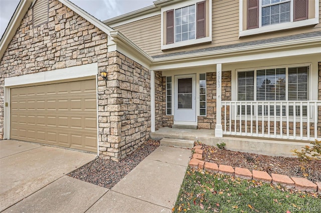 property entrance featuring covered porch and a garage