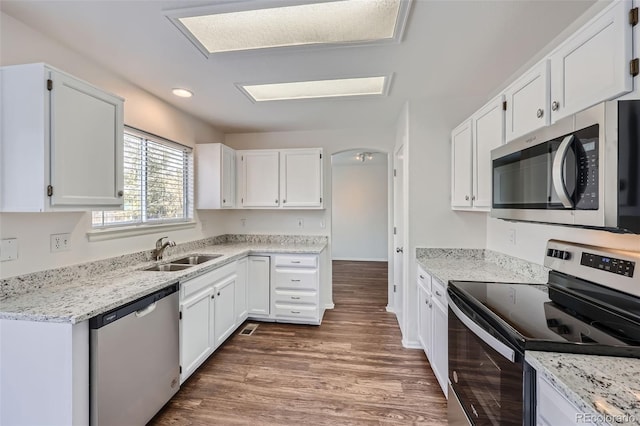 kitchen with sink, appliances with stainless steel finishes, white cabinets, and dark hardwood / wood-style flooring