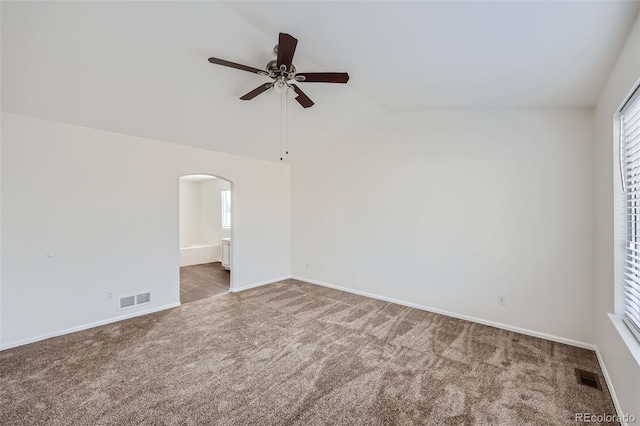 unfurnished room with ceiling fan, lofted ceiling, and dark carpet