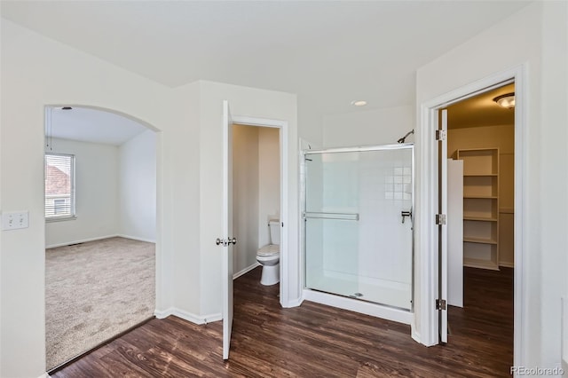 bathroom with toilet, hardwood / wood-style flooring, and a shower with shower door